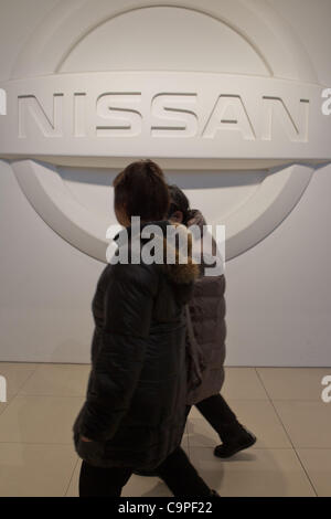 Febbraio 8, 2012 a Yokohama, Giappone - i visitatori a piedi passato il segno Nissan presso la sede della società. In questo terzo trimestre fiscale, Nissan ha riportato un risultato netto aumento al 3,2 percento a 82,7 miliardi di euro dieci (USD 1,07 miliardi). La società del profitto operativo era 118,1 miliardi di yen ($1,53 miliardi di USD) fino 3.6 Foto Stock