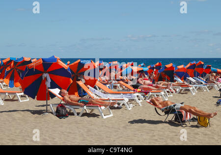 I turisti a prendere il sole sulla spiaggia a Playa del Inglés, Gran Canaria Isole Canarie Spagna, giovedì 16 febbraio, 2012. Lo stesso giorno ha nevicato sul punto più alto dell'isola. Foto Stock