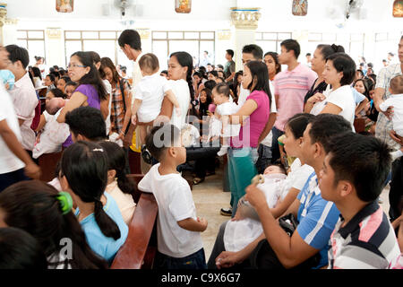 Città Lapu-Lapu, Filippine, 26/02/2012: 200-300 bambini battezzati in un solo 3 ore di cerimonia alla Mactan Air Base cappella. Foto Stock