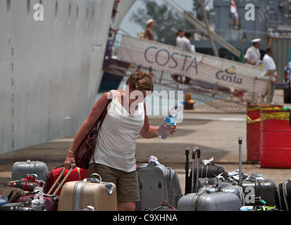 Marzo 01, 2012 - victoria Seychelles - un passeggero raccoglie i suoi bagagli dopo lo sbarco di Costa Allegra. L'italiano la nave di crociera è stato trainato in francese dalla profondità del mare tonno trawler sebbene più velocemente di un rimorchiatore era disponibile. Più di 1.000 passeggeri e membri di equipaggio sbarcò storpi Costa tutti Foto Stock