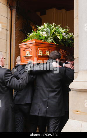 Pall portatori portano una bara in chiesa per una messa funebre. Foto Stock