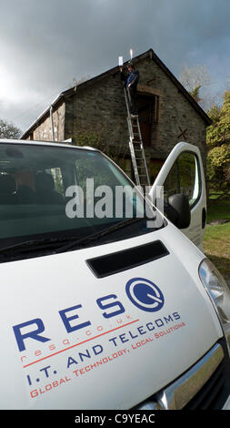 Un tecnico IT installa apparecchiature a banda larga Wireless per una residenza in zone rurali del Galles REGNO UNITO 07.03.2012 Foto Stock