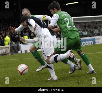 Ayr, Regno Unito. 10/3/12 William Hill Coppa Scozzese Quarti di finale. Ayr Regno v Hibernian (Hibs) Michael McGowan di Ayr Regno (bianco/asfalto) controlla la sfera come egli è chiuso in basso da George Franco (n. 22) e James McPake di Hibs. Foto Stock