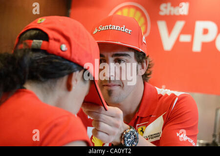 Marzo 15, 2012 - Melbourne, Victoria, Australia - Fernando Alonso i segni di un fan hat a Brunetti cafe in Carlton davanti al la 2012 Formula Uno Australian Grand Prix sul circuito dell'Albert Park di Melbourne, Australia. (Credito Immagine: © Sydney bassa/Southcreek/ZUMAPRESS.com) Foto Stock