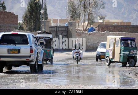 Gli automobilisti passano attraverso il ristagno di acqua di fognatura a Zarghoon strada che sta creando problemi nel normale flusso di traffico che mostra la negligenza del dipartimento interessato, a Quetta mercoledì 21 marzo, 2012. Foto Stock