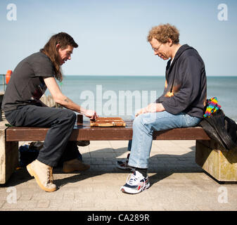 Due persone di giocare a backgammon sul lungomare, godersi il caldo sole meteo primavera al mare, Aberystwyth Wales UK, 24 marzo 2012 Foto Stock