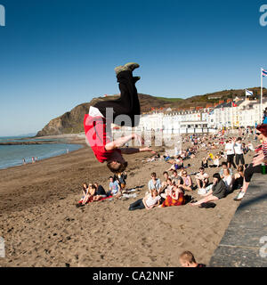 27 marzo 2012. Aberystwyth Wales UK. Come molto calda primavera meteo continua, la folla dei giovani universitari godetevi il sole sulla spiaggia del Galles occidentale stazione balneare Foto Stock