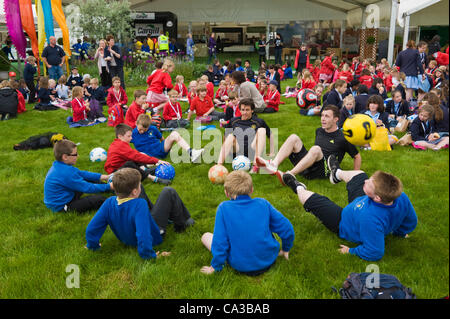 Gli alunni di scuole locali di Powys e Herefordshire Godetevi il pranzo sul prato del festival e mettere in pratica le loro abilità calcistiche presso il Telegraph Hay Festival, Hay-on-Wye, Powys, Wales, Regno Unito Foto Stock