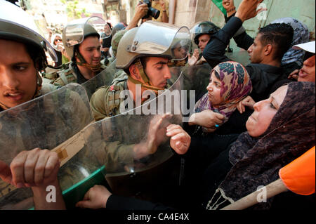 HEBRON, Territori palestinesi - Giugno 5, 2012: le donne palestinesi affrontare i soldati israeliani in una manifestazione nonviolenta per commemorare la Naksa Day, l'anniversario dell'occupazione israeliana dei territori palestinesi nel 1967. Foto Stock