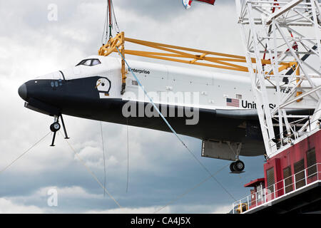 La città di New York, Stati Uniti d'America. 06 Giugno, 2012. Lo Space Shuttle Enterprise detenute dal telaio metallico è sollevato e ruotato da grande gru a ponte della Intrepid Sea Air & Space Museum sul fiume Hudson Manhattan Mid West Side waterfront Foto Stock