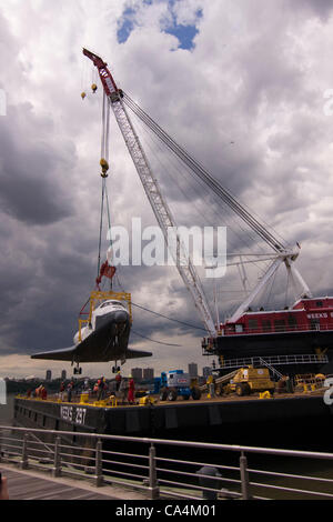 Il 6 giugno 2012. New York City Stati Uniti d'America. I lavoratori da settimane il team Marine Heavy Lift guide lo Space Shuttle Enterprise come il suo essere sollevata da una massiccia pesanti gru di sollevamento dove sarà messo sul ponte della USS Intrepid Portaerei sul fiume Hudson in New York City. Foto Stock