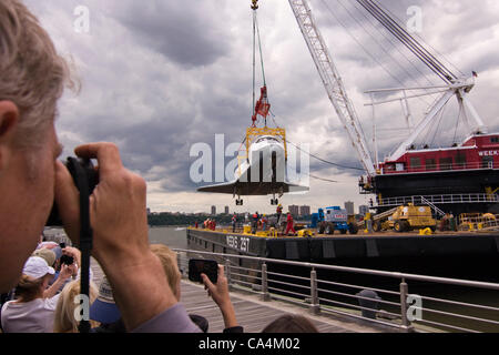 2012. New York City Stati Uniti d'America. Spettatori fotografare lo Space Shuttle Enterprise al suo essere sollevati in aria da una settimane pesanti Marine gru di sollevamento per essere messo in esposizione permanente sul ponte della USS Intrepid. Foto Stock