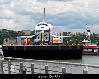 Chiatte che trasportano lo space shuttle Enterprise gira per entrare in museo Intrepid ormeggio per essere trasferiti da una gru a ponte di volo della nave Foto Stock