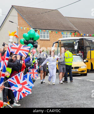 Venerdì 8 Giugno 2012. North Ayrshire, in Scozia, Regno Unito. Angela Oakley, 53, un attivista Fairtrade da Glasgow, portando la torcia Olimpica attraverso il villaggio di Barrmill nel North Ayrshire. Foto Stock