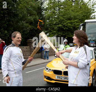 Aboyne, Scozia - Giugno 11, 2012: Karl Kaufmann passando la fiamma olimpica di Amanda Yule durante il 2012 Torcia Olimpica a Aboyne, Scozia Foto Stock