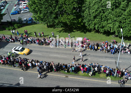 Dunfermline, Regno Unito. Centinaia di persone in linea il percorso come una torcia olimpica runner fa il suo senso giù Carnegie Drive, Dunfermiline, Fife, Scozia. 13 giugno 2012 la torcia era in viaggio attraverso Dunfermline sul suo modo da St Andrews a Edimburgo. Foto Stock