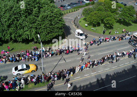 Dunfermline, Regno Unito. Centinaia di persone in linea il percorso come una torcia olimpica runner fa il suo modo giù Carnegie Drive, Dunfermiline, Fife, Scozia. 13 giugno 2012 la torcia era in viaggio attraverso Dunfermline sul suo modo da St Andrews a Edimburgo. Foto Stock