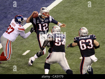 Febbraio 5, 2012 - Indianapolis NEGLI STATI UNITI - New England Patriots quarterback Tom Brady #12 ottiene subito pressioni da parte di New York Giants tackle difensivo Linval Joseph #97 durante il Super Bowl XLVI. Super Bowl XLVI è venuto giù per i secondi finali come New York Giants battere il New England Patriots con un punteggio finale Foto Stock