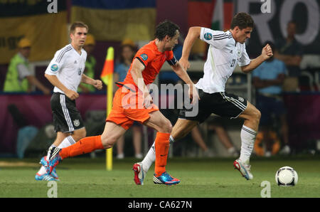 13.06.2012 Ucraina, Kharkiv. Paesi Bassi national team player Mark van Bommel (centro) e nazionale tedesco di giocatori di squadra Mario Gomez (R), Philipp Lahm (L) nella fase di gruppo il Campionato Europeo di calcio match tra squadre di Paesi Bassi e Germania. Foto Stock