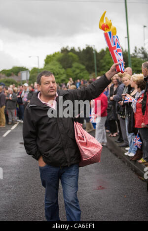 Un venditore di souvenir con un gonfiabile torcia olimpica, per la vendita alla folla si colleghi in attesa per l arrivo del 2012 Torcia Olimpica a Consett, County Durham il 16 giugno. Foto Stock