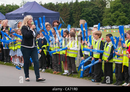 Radio Leeds presenter Georgey Spanswick divertente & parla alla folla (scolari) in piedi e in attesa per la Torcia Olimpica a lato della trasmissione principale - Harewood House, West Yorkshire, Inghilterra, Regno Unito martedì 19 giugno 2012. Foto Stock