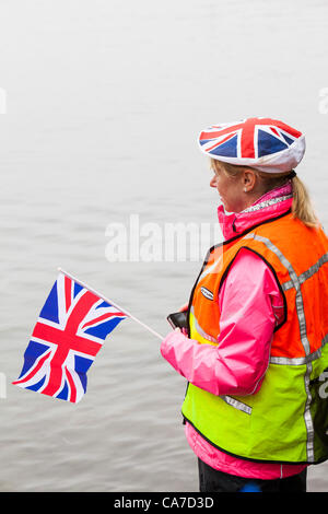 Giovedì 21 Giugno 2012. Uno steward sorge nel lago di Windermere, come la fiaccola olimpica passa attraverso Ambleside e viaggi a Bowness su una barca, Lake District, UK. Foto Stock