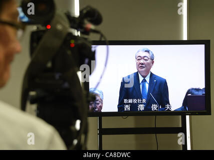 Giugno 27, 2012, Tokyo, Giappone - Presidente Toshio Nishizawa di Tokyo Electric Power Co., è mostrato su un monitor pressroom come egli parla all'inizio della sua annuale degli azionisti a Tokyo il Mercoledì, 27 giugno 2012. Da otto a 20 Utilità alimentazione amministratori e sindaci otterrà posizioni lucrativo presso le società del gruppo in paracadute d'oro dopo le loro dimissioni di assumersi la responsabilità per la crisi. Più di 3.000 gli azionisti interessati tra cui governo metropolitano di Tokyo ha partecipato alla riunione. (Foto di Natsuki Sakai/AFLO) Foto Stock