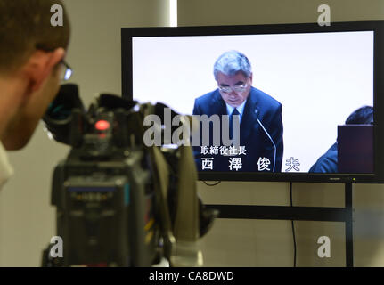 Giugno 27, 2012, Tokyo, Giappone - Presidente Toshio Nishizawa di Tokyo Electric Power Co., è mostrato su un monitor pressroom come egli parla all'inizio della sua annuale degli azionisti a Tokyo il Mercoledì, 27 giugno 2012. Da otto a 20 Utilità alimentazione amministratori e sindaci otterrà posizioni lucrativo presso le società del gruppo in paracadute d'oro dopo le loro dimissioni di assumersi la responsabilità per la crisi. Più di 3.000 gli azionisti interessati tra cui governo metropolitano di Tokyo ha partecipato alla riunione. (Foto di Natsuki Sakai/AFLO) Foto Stock