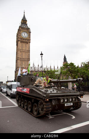 Londra, Regno Unito. Mercoledì 27 Giugno 2012. Il serbatoio è passata attraverso la piazza del Parlamento passato il Big Ben e il Parlamento. Gli attivisti e sostenitori di Oxfam e Amnesty International, come parte dei bracci di controllo di coalizione, guidare un Abate Serbatoio di pistola intorno al centro di Londra per evidenziare la necessità di un glo Foto Stock