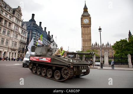 Londra, Regno Unito. Mercoledì 27 Giugno 2012. Il serbatoio è passata attraverso la piazza del Parlamento passato il Big Ben e il Parlamento. Gli attivisti e sostenitori di Oxfam e Amnesty International, come parte dei bracci di controllo di coalizione, guidare un Abate Serbatoio di pistola intorno al centro di Londra per evidenziare la necessità di un glo Foto Stock