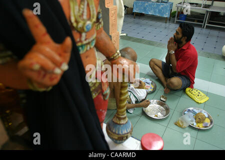 KUALA LUMPUR, Malesia febbraio , 2004 25 anno Gunasegran, per la prima volta partecipante al festival riceve le benedizioni per la protezione dal sacerdote Indù presso il suo tempio nel centro cittadino di Kuala Lumpur alla vigilia del festival di Thaipusam 4 febbraio. 2004. Trenta o più giorni di digiuno e di ore di rendere il Cav Foto Stock