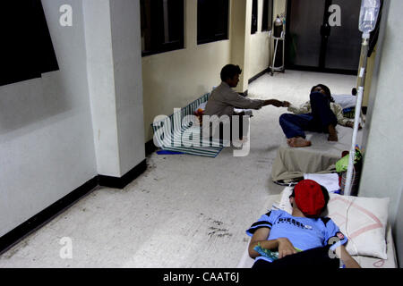 Febbraio 24,2004 JAKARTA, Indonesia pazienti la febbre emorragica della dengue sul loro letto extra mentre la loro madre li accudiscono al Budhi Asih East Jakarta District Hospital che già al completo con pazienti DHF dato che un paio di settimane prima Foto di negare/JiwaFoto/ZUMA premere Foto Stock