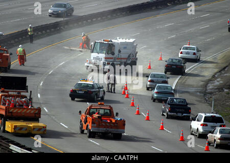 Il traffico è limitato a una corsia mentre gli equipaggi Caltrans ripulire il contenuto rimanente da un camion rovesciato su autostrada westbound 24 appena ad ovest del Caldecott in tunnel di Oakland, California, giovedì 6 febbraio 2004. (Dean Coppola/Contra Costa Times) Foto Stock