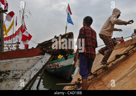 Gli abitanti di un villaggio al villaggio fisheman board sulla barca durante un pescatore alms cerimonia del mare o Tradisi Nyadran nella lingua locale in Marunda periferia di Jakarta, luglio 25, 2010.Tradisi Nyadran è una tradizione della comunità costiere è un simbolo del rapporto con gli antenati, colleghi, Dio e l'universo, come Foto Stock