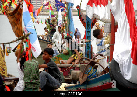 Gli abitanti di un villaggio al villaggio fisheman board sulla barca durante un pescatore alms cerimonia del mare o Tradisi Nyadran nella lingua locale in Marunda periferia di Jakarta, luglio 25, 2010.Tradisi Nyadran è una tradizione della comunità costiere è un simbolo del rapporto con gli antenati, colleghi, Dio e l'universo, come Foto Stock