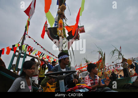 Gli abitanti di un villaggio al villaggio fisheman board sulla barca durante un pescatore alms cerimonia del mare o Tradisi Nyadran nella lingua locale in Marunda periferia di Jakarta, luglio 25, 2010.Tradisi Nyadran è una tradizione della comunità costiere è un simbolo del rapporto con gli antenati, colleghi, Dio e l'universo, come Foto Stock