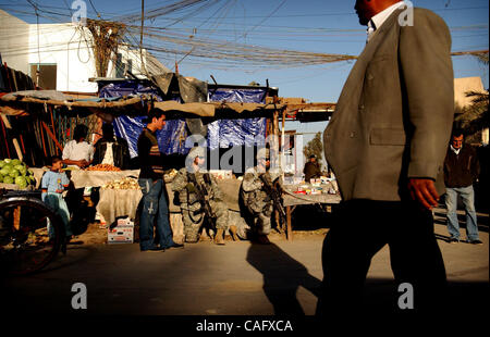 Feb 21, 2008 - Baghdad in Iraq - gli acquirenti andare circa la loro attività come un paio di ottantaduesima Airborne Division paracadutisti prendere un ginocchio nel mercato del pesce in enclave sunnita di Shabakar in Rabi quartiere di Baghdad. (Credito Immagine: © Andrew Craft/ZUMA Press) Foto Stock