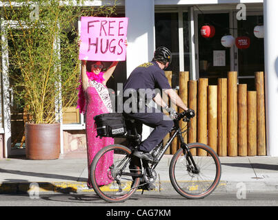 A Berkeley funzionario di polizia occhi Nancy Mancias, un codice colore rosa attivista di pace, che è stata offerta Free Hugs attraversata la strada dal Berkeley Marine Corps ufficio reclutamento giovedì. Rosa codice tenuto un Kiss-In presso l' Ufficio per la promozione della pace. Foto Stock