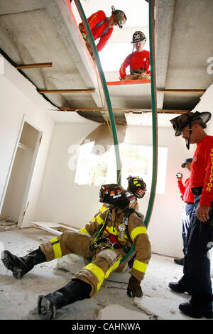 Dic 11, 2007 - West Palm Beach, Florida, Stati Uniti d'America - Vigili del Fuoco pratica il 'Nance Drill' per il salvataggio di un vigile del fuoco che è caduto attraverso il pavimento in un livello inferiore. Questo esercizio è stato sviluppato dopo un Columbus, Ohio pompiere, John Nance, è stato ucciso dopo la caduta attraverso il piano principale di una casa int Foto Stock