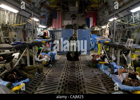 Af Senior Airman Travis Silko, Un medico tecnico assegnato all'86º AES (Istituto di medicina aeronautica squadrone di evacuazione) basato a Ramstein, in base aerea, Germania, scrive la sua relazione come egli tende a gravemente ferito ai soldati feriti in Afghanistan a bordo di un Mississippi Air National Guard C-17 cargo aereo en route Foto Stock