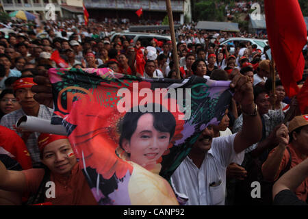 Persone celebrare presso la sede della Lega nazionale per la democrazia, sventolando poster di icona della democrazia Aung San Suu Kyi in Yangon, 1 aprile 2012. Foto Stock