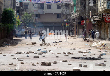 Manifestanti arrabbiati masterizzare il blocco pneumatico road con pietre come lo scoppio di violenza in area Liyari contro l uccisione di una gioventù in polizia incontro a Karachi il lunedì, 02 aprile 2012.. Foto Stock