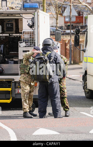 Belfast, Regno Unito. 05/04/2012 - Esercito Technical Officer mette su un a prova di bomba suit durante un avviso di protezione nel Ardoyne. L'oggetto è stato successivamente dichiarato una beffa. Foto Stock