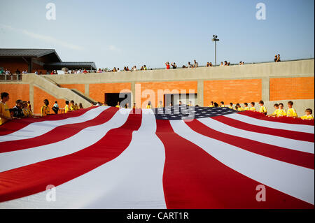 Aprile 15, 2012 - San Antonio, TX, Stati Uniti d'America - Bambini tenere una bandiera americana che si preparano per le cerimonie pregame durante la cerimonia inaugurale partita in casa del San Antonio scorpioni squadra di calcio della North American Soccer League Domenica, 15 aprile 2012. Il team è di proprietà dell'imprenditore Gordon Hartman e pro Foto Stock