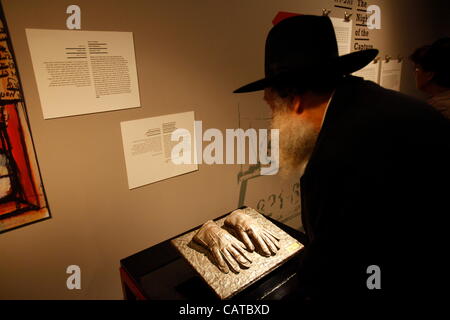 Un ebreo ortodosso osservando la replica dei guanti che sono state utilizzate da un Israeliano agente del Mossad durante la cattura del SS ufficiale nazista Adolf Eichmann in Argentina nel 1960 visualizzati in una mostra a Beit Hatfutsot, il museo del popolo ebraico a Tel Aviv Foto Stock