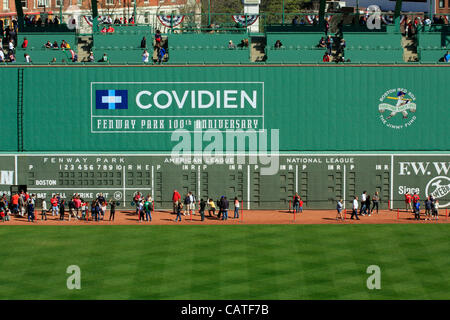 Boston, Massachusetts, USA. Aprile 19, 2012. Decine di Red Sox fans sedersi al mostro verde posti al Fenway Park il suo centesimo anniversario Open House mentre centinaia di camminare sulla via di avvertimento per ottenere uno sguardo più da vicino al mostro verde parete e il quadro di valutazione in campo sinistro. Foto Stock