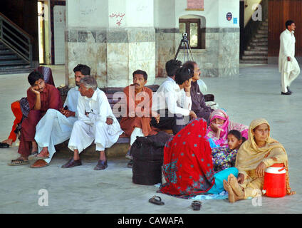 I passeggeri di attendere per il loro treni in una piattaforma a Lahore stazione ferroviaria Mercoledì, 25 Aprile 2012.Con la morte di sette-anno-vecchio figlio di mercoledì, con pedaggio da letali blast a Lahore stazione ferroviaria montato a tre come più di 45 persone sono rimaste ferite. Una bomba è esplosa vicino Foto Stock