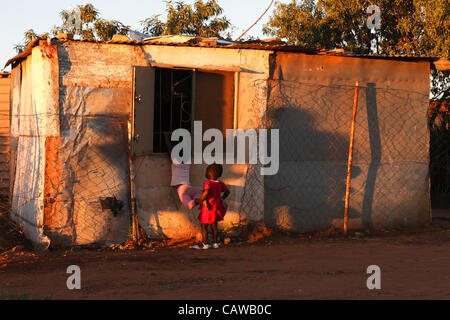 Due bambine tentare di ottenere una sbirciatina all'interno di una finestra in una cittadina alla periferia di Johannesburg, Sud Africa. Julia Cumes/Zuma Foto Stock