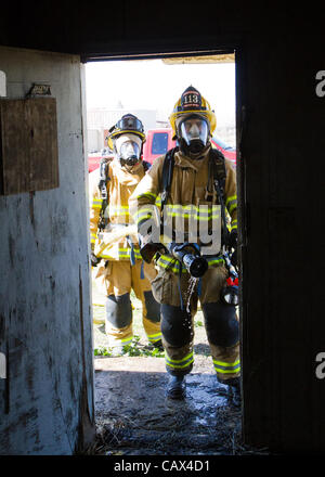 3 marzo 2012 - Modesto, CA, Stati Uniti d'America - Vigili del Fuoco da Hughson Vigili del Fuoco guardare dentro una porta come essi pronti a entrare nella casa durante un incendio di formazione. Vigile del fuoco da circa Stanislao county al lavoro (credito Immagine: © Marty Bicek/ZUMAPRESS.com) Foto Stock