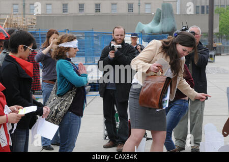 Il 1 maggio, 2012, un piccolo gruppo di occupare Toronto manifestanti emanare un pezzo di teatro di strada in base al movimento dei pezzi su una scacchiera, a Nathan Philips Square, Municipio di Toronto, Ontario, Canada. Foto Stock